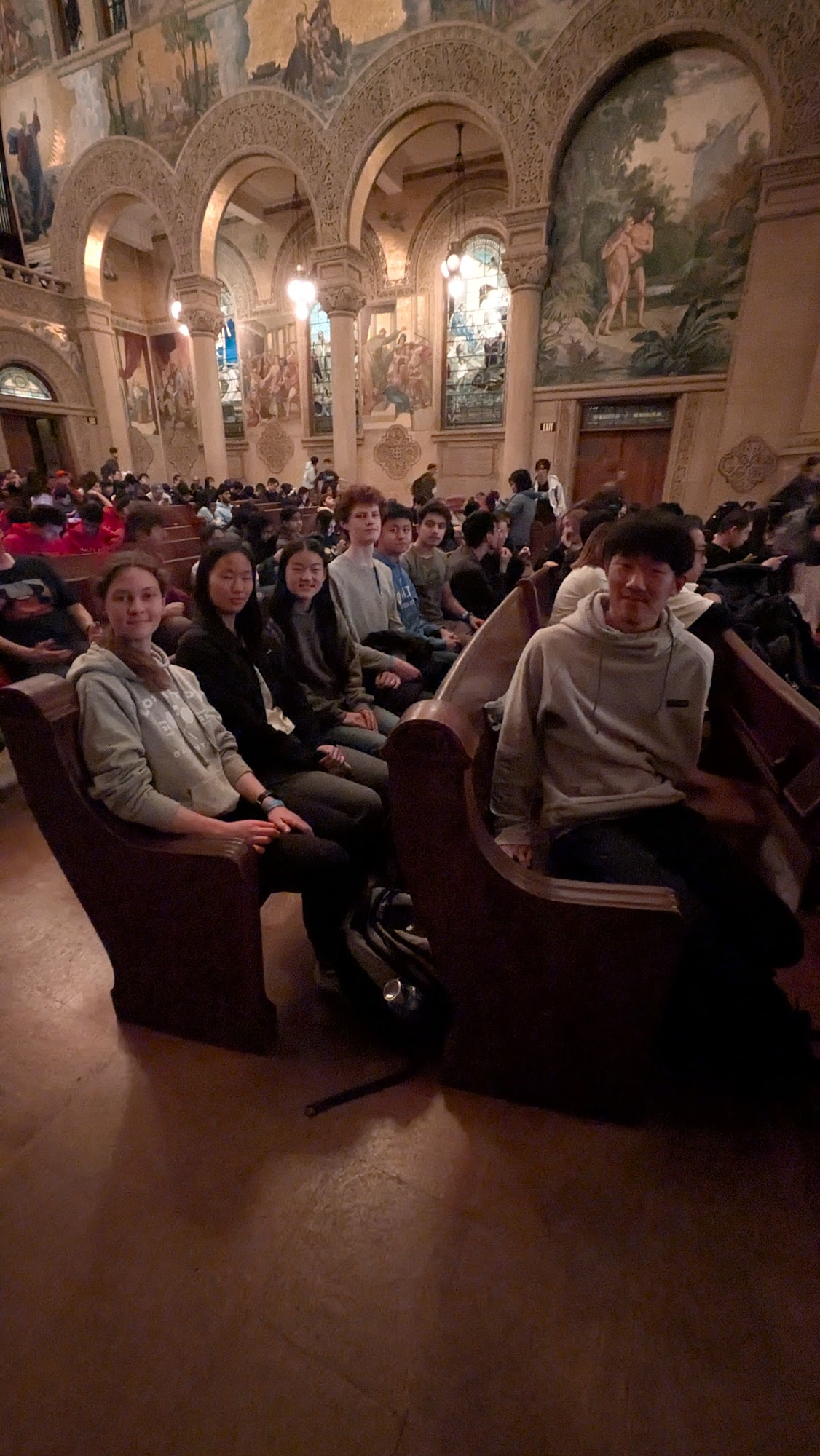 Students seated together inside a large building