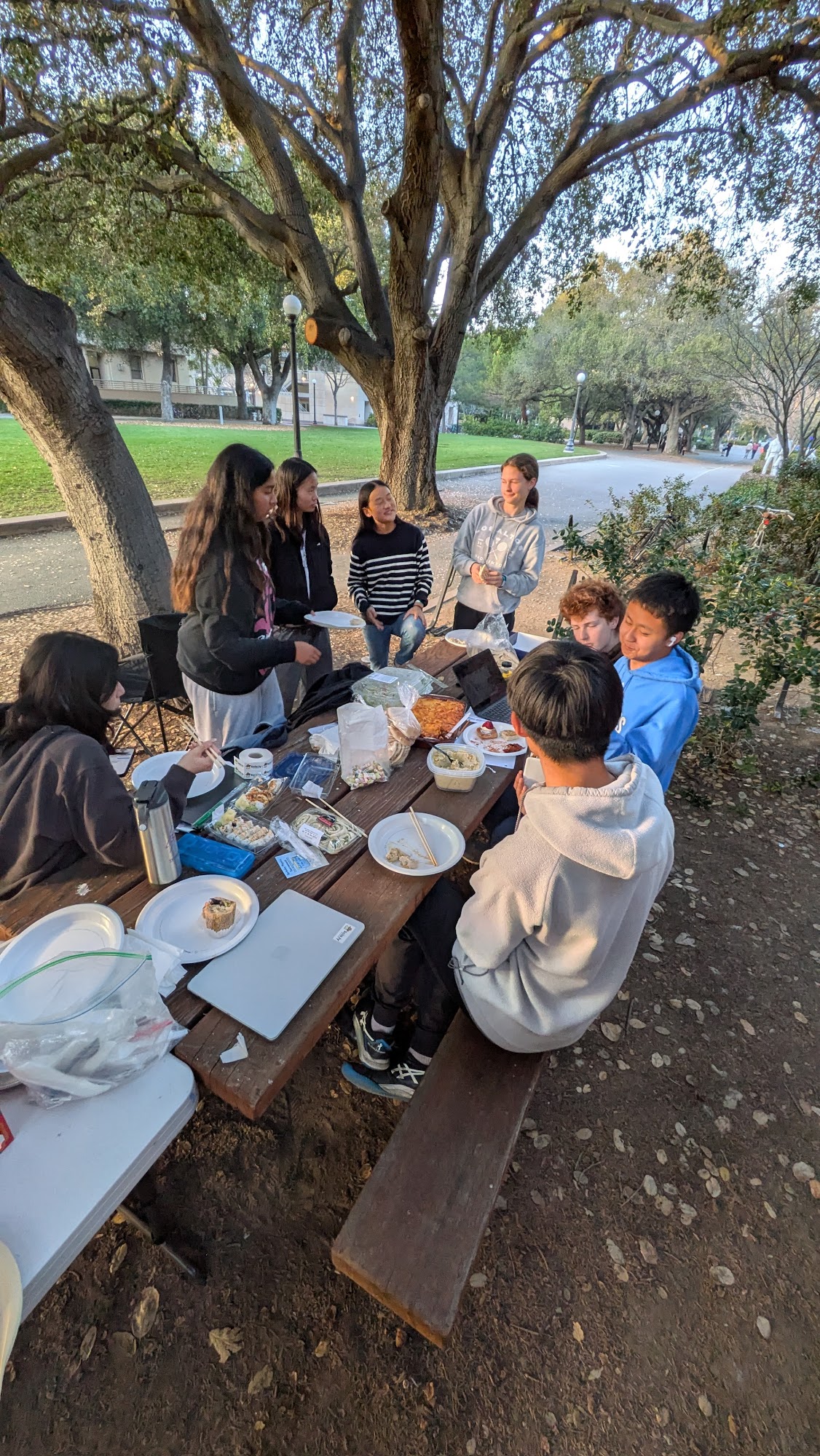 Students gathered around an outdoor picnic table